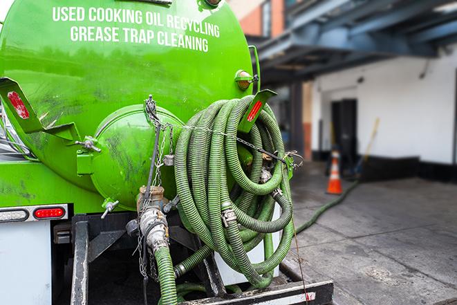 a professional technician pumping a restaurant's grease trap in Birmingham